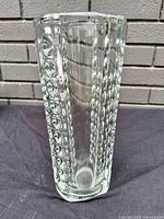 Top-down view of the clear crystal vase showing the bubble texture and thick base on a dark fabric surface.