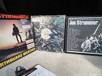 Overview photo showing Joe Strummer Earthquake Weather vinyl on left, vinyl with graffiti cover in middle, and Steel City Rockers tribute vinyl on right.
