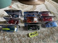 Overhead view of nine Hot Wheels cars in original blister packaging on a table with lace tablecloth.