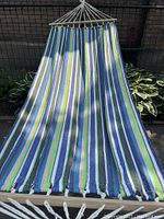 Full view of the hammock fabric showing the striped pattern and wooden spreader bar at top.
