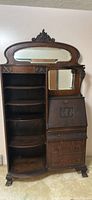 Full front image of the antique side-by-side secretary desk in dark oak with carved details and mirror