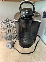 Front view of Keurig coffee maker on kitchen counter with pod rack and coffee pod holder beside it