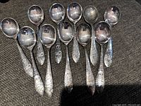 Set of 11 metal spoons with Mickey Mouse embossing on the handles, showing full spoon faces and handles