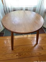 Photo of the round top and tabletop surface showing wood grain and finish.