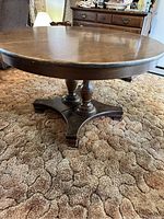 Side view showing round laminate topped table with decorative turned pedestal base legs