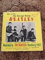 Front of yellow album paper cover featuring young Beatles photo with band member names and song titles.
