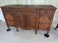 Front view of the vintage Bernhardt buffet cabinet showing the carved wood details and ornate handles on drawers and doors.
