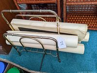 Brass bamboo-style magazine holder containing several rolled vintage artwork prints