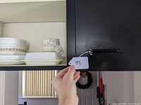 Shot of upper kitchen cabinet showing Corelle Golden Butterfly dinnerware and butter dish stacked on shelves.