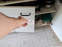 White cupboard door with label '48' held by hand in front.