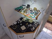 Overview showing two-tier corner shelf with assorted jewelry laid out