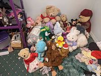 Full view of assorted vintage plush including Care Bears, Mickey and Minnie Mouse, large teddy, bunny, monkey, dinosaur and duck character plush toys.
