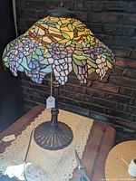 Side angle showing the grapevine mosaic stained glass shade with various colors, highlighting purple grapes, green leaves and yellow background.
