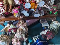 Photo showing various dolls on a wooden surface likely the walnut coffee table described.