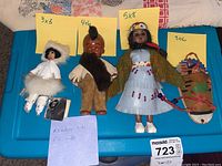 Four dolls including ANAC certified Alaskan reindeer skin doll, Native American boy doll, Native American woman doll with baby, and Wyoming Native American baby doll in cradle