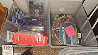 Box of various computer accessories including cables, adapters, and fans.