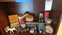 Lot displayed on shelf including candles, brass figurines (crab and lizard), geodes, basketry coasters, tissue holder, assorted small figurines, and boxes.
