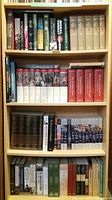Four shelves containing assorted hardcover history books and multivolume sets