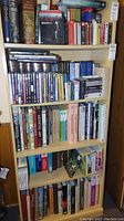 Five-shelf wooden bookcase filled with books, DVDs and CDs