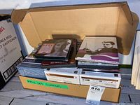 Cardboard box containing stacked classical music CDs in jewel cases and slipcases