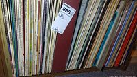 Shelf with numerous vinyl LP records stored vertically with visible album spines showing variety of titles and artists