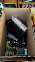 Cardboard box containing black and red blank albums or folders, some miscellaneous supplies and items related to stamp collecting.