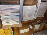 Boxes filled with stacked Marie Claire and Elle magazines on shelving units.
