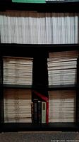 Four-shelf unit filled primarily with Vogue magazine issues; second shelf center has a row of books