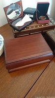 Wooden boxes and boxes containing medallion and wallet placed on table, largest wooden box closed