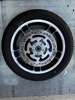 Front wheel showing aluminum alloy rim, tire, and disc brake rotor with holes.