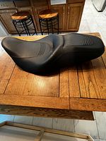Side angled view of Harley Davidson black motorcycle seat showing contour shape for rider and passenger.