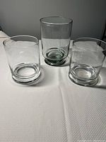 Photo showing all three clear glass hurricane candle holders, two shorter and one taller