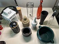 Overview of all items in the lot on a beige surface showing lantern, vases, holders, and bowl-shaped items