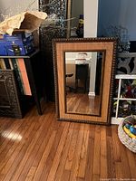 Front view of the rectangular wall mirror showing the woven wicker, bamboo and wood frame with clear mirror glass.