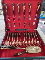 Full set of Fire Bird silverware in original box, showing 6 knives in upper slot and 6 forks, 6 spoons, serving utensils in lower slot with red velvet lining