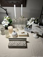 Overall assortment of shabby chic home decor items including candles, holders, flowers, boxes, shelf, and note holder.