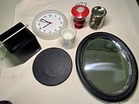 Full group view showing all items: white wall clock, red lantern, metal tray with black leather rim, napkin holder, mouse pad, glass candle holder and metal wax melt holder.