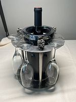 Front angled view of silver wine chiller holding a wine bottle and five wine glasses hanging upside down.