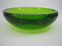 Side view showing bowl shape, green glass color and bubble pattern.