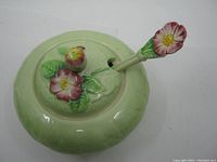 Top view of green Carlton Ware sugar bowl with lid and floral spoon in place