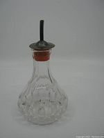 Front view showing overall shape, cut crystal pattern, and sterling silver top with spout.