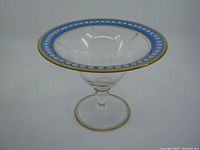 Front and angled view showing the entire pedestal dish with flared rim, blue and white etching detail, and gold trim wear.