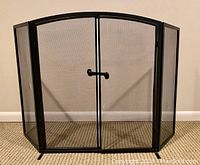 Full view of the arched wrought iron fire screen with front latched doors and folding side panels.