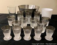 Full view of set showing all glasses arranged in front of two barrels - stainless steel bowl and white small ice bucket.