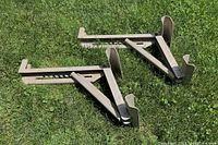 Pair of Stinson Flyweight ladder jacks lying flat on grass, showing general shape and metal construction.