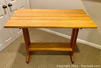 Full view of the rectangular hardwood trestle table showing the tabletop and legs.