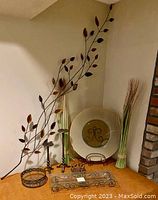 Full lot view showing wall hanging, candle pedestals, ceramic dish, basket, plant stand, and decorative grasses arranged in a corner.