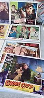 Photo showing six vintage movie lobby cards including 'The Long Night' featuring Henry Fonda, 'Crime City,' and 'Female Jungle'. Colorful illustrated cards with classic movie scenes.