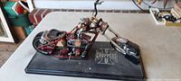 Side view of 14 inch die cast West Coast Choppers motorcycle on black base showing details and dust accumulation.