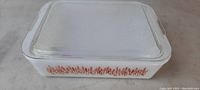 Top view of rectangular milk glass style baking dish with textured clear glass lid on top.